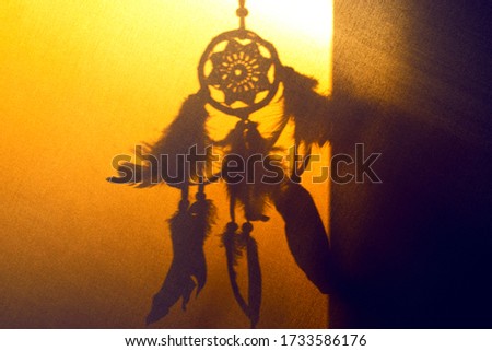 The silhouette of a dreamcatcher in the sunset.