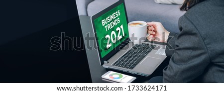 Business Trends for 2021 on laptop screen with businesswoman holding coffee cup,Digital Business disruption or marketing trending.digital transformation.banner mockup leave space for add text
