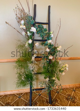 A decorated ladder with fresh flowers for a special event.