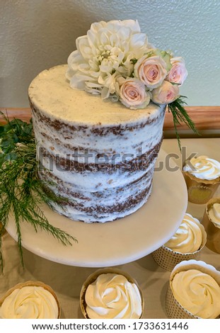 A beautiful small cake decorated with fresh flowers.