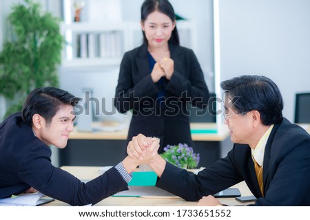 Competition and conflicts of the new generation with the older generation In an organization or establishment, Two Generation Businessman Competing In Arm Wrestling