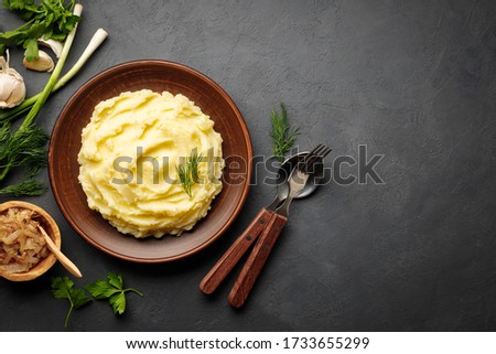 Mashed potatoes, boiled puree in a brown plate on a black slate background. Top view. Flat lay. Copy space. Royalty-Free Stock Photo #1733655299