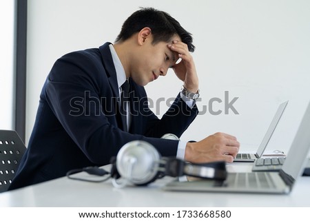 Close up Call center asian man feeling stress from work in the office , Call center operator having a headache