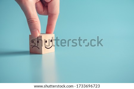 Close up customer hand choose smiley face and sad face icon on wood cube, Service rating, satisfaction concept, copy space. Royalty-Free Stock Photo #1733696723