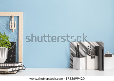Home office desk with copy space on blue wall. Stylish creative workspace mock up.