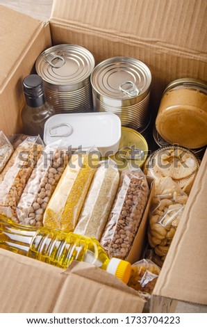 Set of uncooked foods in carton box prepared for disaster emergency conditions or giving away closeup view Royalty-Free Stock Photo #1733704223