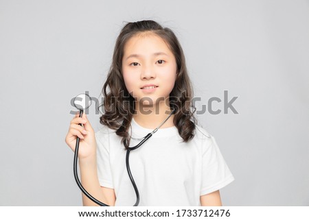 Asian elementary school girl on gray background