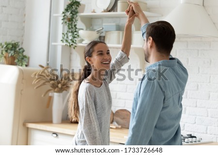Overjoyed millennial husband and wife dancing in modern kitchen celebrate wedding anniversary at home together, happy young couple tenants have fun enjoy family weekend in new own house or apartment Royalty-Free Stock Photo #1733726648