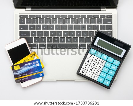 Modern white office desk table with laptop computer, smart phone, Credit card and Calculator.