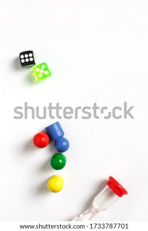 Game cubes, chips, hourglass on a white background. The concept of home Board games, classes at home with children, developmental training, logic games. Flatlay and space for text