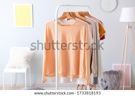 fashionable clothes on a rack in a bright interior of the wardrobe room
