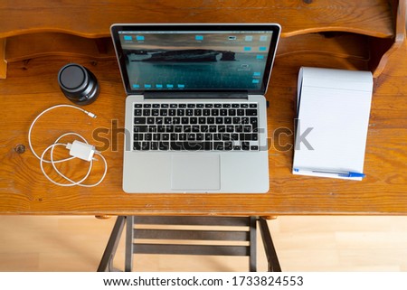 laptop, charger, lens and bloc on a wood table