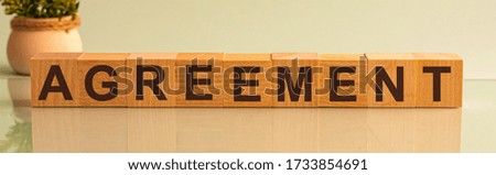 AGREEMENT word on wooden cubes on yellow background