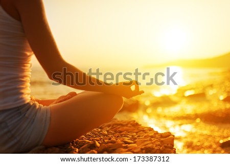 hand of a woman meditating in a yoga pose on the beach Royalty-Free Stock Photo #173387312