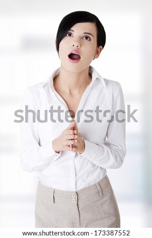 Shocked businesswoman looking up