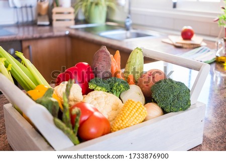 White wooden basket in the kitchen with variety of fresh raw vegetables. Healthy eating concept - detox diet - vegan or vegetarian lovers