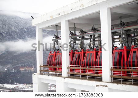 ski lift in the mountains with red cabins