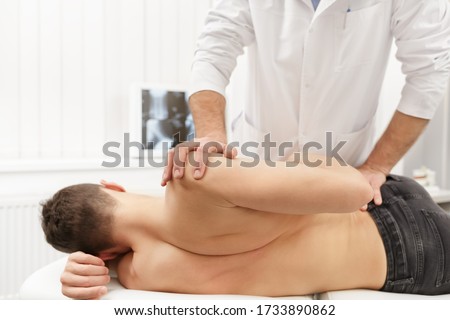 Manual therapist doing manual adjustment on patient's spine. Chiropractic, osteopathy, manual therapy, post traumatic rehabilitation, sport physical therapy. Alternative medicine, pain relief concept. Royalty-Free Stock Photo #1733890862
