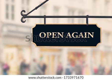 Open again sign board against open shop windows background. Restarting business after coronavirus quarantine lockdown. Economy reopening concept