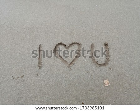 The inscription on the sand is I love you.