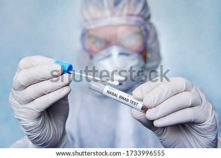 Diagnostic testing for COVID-19. Nasal swab laboratory test in hospital lab. Specialist holding test tube with cotton swab, medical science professional taking sample. test tube in hand of scientist Royalty-Free Stock Photo #1733996555