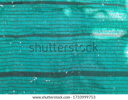 Surface sun shading net, green slant fabric pattern with white drops and light, for sunlight protection, horizontal image
