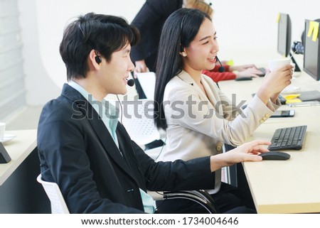 Smiling of Business people Call Center and technical Support staff. Receptionist phone operators teamwork relax and drinking coffee. Asian customer support team.