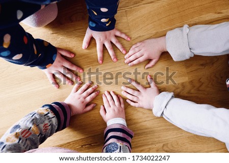 A beautiful picture of kids showing up their hands on a wooden floor