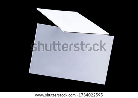 White triple business cards, floating on a black background, a mock-up Royalty-Free Stock Photo #1734022595