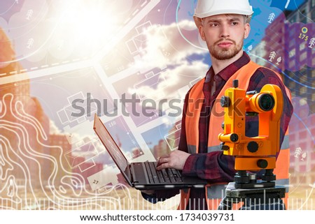 Cartography. The cartographer stands next to theodolite. A man in a white hard hat is holding a laptop. Working on geographical maps. Geodetic equipment. Study of the area. Royalty-Free Stock Photo #1734039731