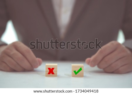 Business decision concept. Businessman manager confuse to make decision with project between approve or reject. Hand arranging symbol with icon on wood cube block. Solution to success project