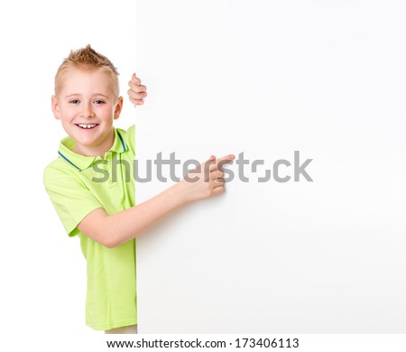 Handsome kid boy pointing to blank advertisement banner