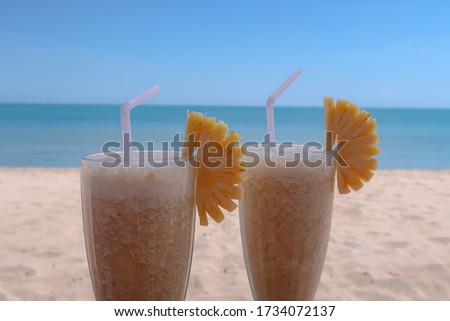 A picture of glasses of juice on the beach.Very attractive background of beach.