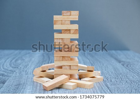 Image of blocks wood game to growing up of business. Risk of management and strategy plan.