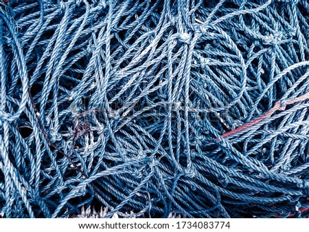 Fishman net. Navy-blue fishnets of rope knots and blue maritime background.