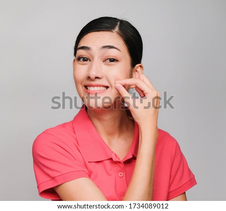 young beautiful asian woman wore pink t shirt, Showed Keep quiet expression , on gray background