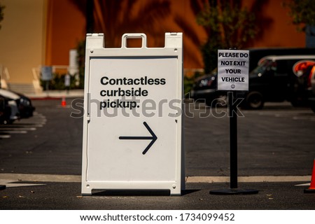 Sign advertising Contactless Curbside Pickup at retail store parking lot Royalty-Free Stock Photo #1734099452