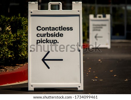 Sign advertising Contactless Curbside Pickup at retail store parking lot Royalty-Free Stock Photo #1734099461