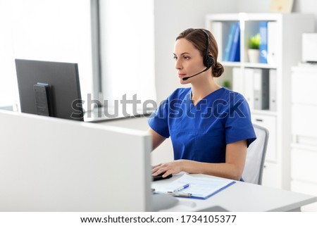 medicine, technology and healthcare concept - female doctor or nurse with headset and computer working at hospital Royalty-Free Stock Photo #1734105377