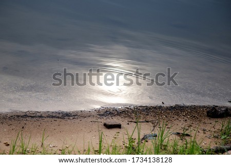 Reflection of the sun by blue river