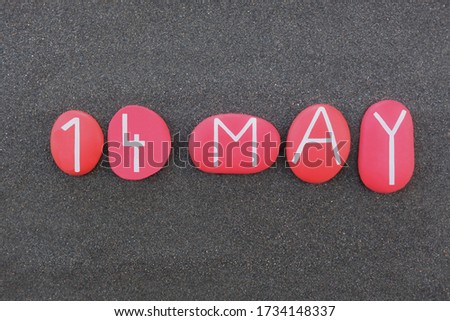 14 May, calendar date composed with red colored and carved stones over black volcanic sand 
