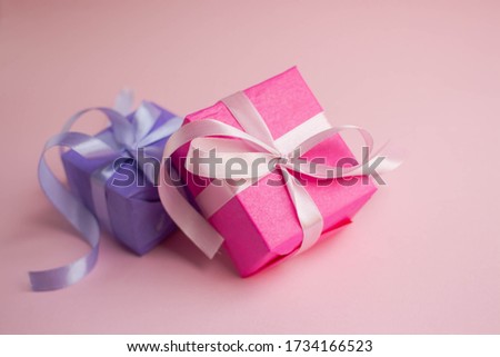 pink and lilac gift boxes on pink with bokeh. present time. 