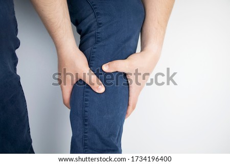 A man suffers from pain in the calves. Stretching the calf muscle, varicose veins, leg cramps, or myositis. Orthopedic doctor examines Royalty-Free Stock Photo #1734196400