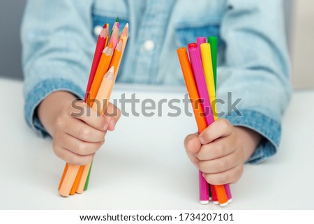 A child holds a felt pens and pencils. Back to school concept.