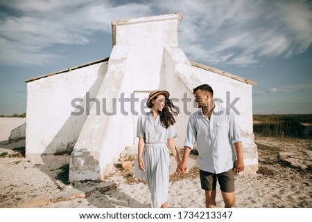 Happy man and woman walking on the beach on their summer vacation
