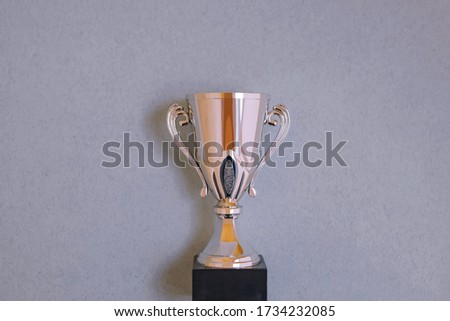 Golden cup on a gray background, a symbol of victory.