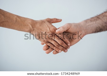 Cropped view of men shaking hands isolated on grey