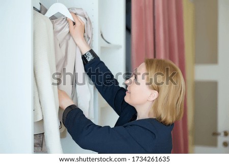 a woman chooses clothes on a rack in a showroom. boutique
