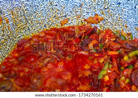 Closeup picture of Hungarian cooked style stew in a cauldron. Food cooked on open air in the United Kingdom with a rustic wooden handmade spoon
