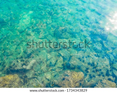 Stone texture under wave blue sea with over light on top view for assembling an article about travel in summer holiday or ocean coast nature.
